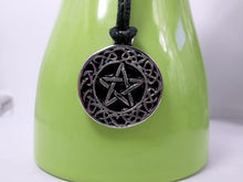 Load image into Gallery viewer, Celtic pentacle pendant necklace, round pendant with black background, on black cord, for unisex teen or adult. (photo taken on a green background)