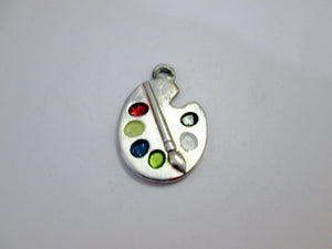 close up of Artist palette pendant necklace on black cord, with painted paint sports, for unisex teen or adult. (photo taken on a white background)