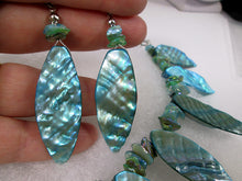 Load image into Gallery viewer, closeup view of iridescent teal shell leaf earrings