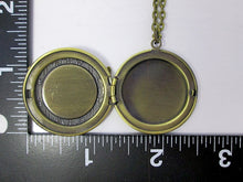 Load image into Gallery viewer, Glow in the dark bird locket necklace open shows keepsake space, alongside with a black L shape ruler to show measurement and size.