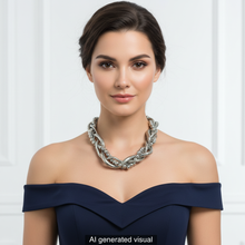Load image into Gallery viewer, A woman with dark hair pulled back wears a chunky silver braided necklace with chunky coils, silver balls, and metal chains.   A small "AI generated visual" label appears at the bottom.

