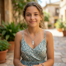 Load image into Gallery viewer, A young woman with light brown hair is wearing a sage green floral print camisole and a silver chain crystal point necklace, photographed in a sunny outdoor courtyard with a blurred background.  A small "AI-generated visual" label appears at the bottom.