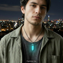 Load image into Gallery viewer, A close-up portrait of a man wearing a silver chain necklace with a blue glow crystal point pendant, layered over a dark gray t-shirt and a green striped button-up shirt, with a blurred outdoor city background.  A small "AI-generated visual" label appears at the bottom.