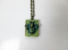 Load image into Gallery viewer, Antique bronze bee book locket necklace with verdigris patina