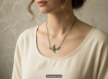 Load image into Gallery viewer, A close-up of a woman wearing a delicate bronze chain necklace with a green bird pendant, styled with a cream-colored scoop-neck top against a textured beige wall.  A small "AI-generated visual" label appears at the bottom.