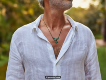 Load image into Gallery viewer, A man wearing a vintage bronze hummingbird necklace necklace over a white linen shirt, photographed outdoors with a blurred green background. A small 'AI-generated visual' label appears at the bottom.