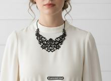 Load image into Gallery viewer, A close-up of a woman wearing a black ornate lace bib necklace over a cream mock-neck blouse, set against a light gray paneled background. A 'AI-generated visual' label is visible at the bottom.