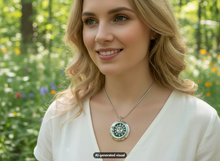 Load image into Gallery viewer, A woman outdoors wearing a antique silver tone sun and moon locket necklace.  The background is a blurred green garden.  A small "AI-generated visual" label appears at the bottom.