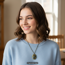 Load image into Gallery viewer, A smiling young woman with shoulder-length brown wavy hair wears a light blue knit sweater and a bronze mouse locket necklace. The photo is taken indoors with a softly blurred warm-toned room in the background.