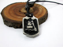 Load image into Gallery viewer, close-up front view of handmade pewter paddler pendant necklace, pendant with black background, on black cord, for men or women (photo of necklace taken on a background with a piece of wood)
