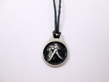 Load image into Gallery viewer, Aquarius horoscope pendant necklace on black cord with black background, teardrop shaped, for man or woman. (photo taken on a white background.)