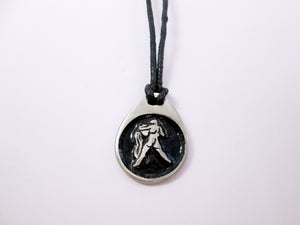Aquarius horoscope pendant necklace on black cord with black background, teardrop shaped, for man or woman. (photo taken on a white background.)