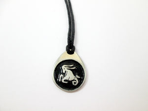 Capricorn horoscope pendant necklace on black cord, teardrop pendant with black background,  for man or woman. (photo taken on a white background)