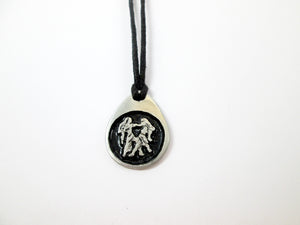 Gemini pendant necklace on black cord, teardrop pendant with black background, for man or woman. (picture taken on a white background)