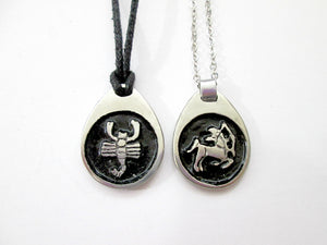 sample of Scopio pendant on black cord and Sagittarius pendant on metal chain. (picture taken on a white background). for man or woman.