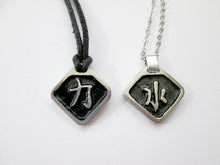 Load image into Gallery viewer, samples of Chinese symbol pendants with black background, diamond shape.  From left to right, symbol of Strength pendant on black cord and Chinese symbol of Water pendant on metal chain.  