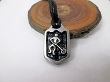 Load image into Gallery viewer, close-up view of handmade pewter ringette player pendant necklace, pendant with black background, on black cord, for men or women. (photo of necklace taken on a background with a piece of wood)