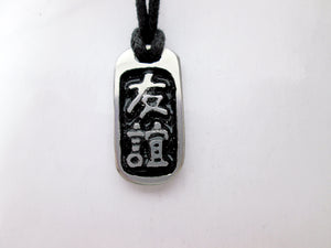 Kanji symbol for Friendship pendant with black background, black cord necklace style.
