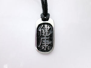 Kanji symbol for Good Health pendant with black background, black cord necklace style.