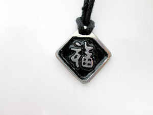Kanji symbol for Good Luck pendant with black background, black cord necklace style.
