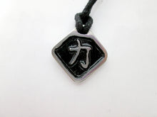 Load image into Gallery viewer, Kanji symbol for Strength pendant necklace, pendant with black background, on black cord.