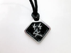 Chinese symbol of laugh pendant necklace, pendant with black background, on black cord.