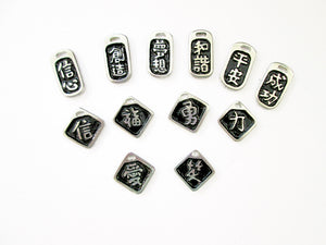 a display of good vibes Chinese symbol pendants with black background.  Top row from left to right; symbol of Confidence. creative, dream or goal, harmony, serenity, success. Midle row from left to right; symbol of faith or belief, good luck, courage and bravery, strength.  Boton row from left to right; symbol of love, love. 