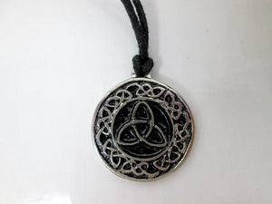 Celtic trinity knot pendant necklace, round pendant with black background, on black cord, for unisex teen or adult . (Photo taken on a white background)