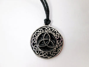 Celtic trinity knot pendant necklace, round pendant with black background, on black cord, for unisex teen or adult . (Photo taken on a white background)