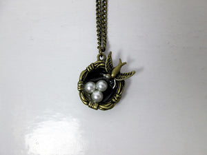 small mama bird necklace with three bird eggs in nest