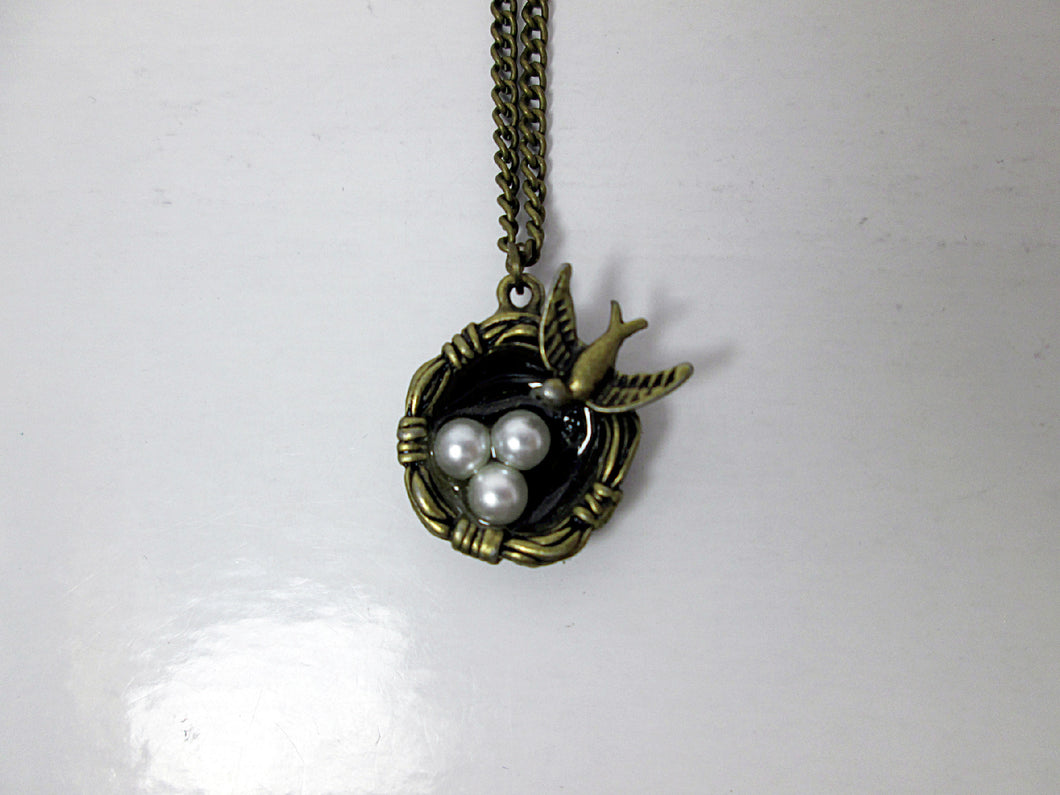 small mama bird necklace with three bird eggs in nest