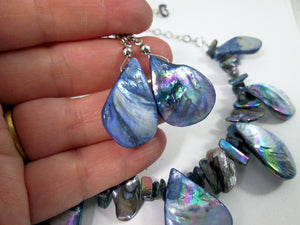 closeup view of rainbow blue seashell earrings