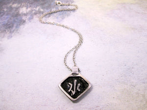 Kanji symbol for element of  water pendant necklace, pendant with black background, necklace on metal chain.