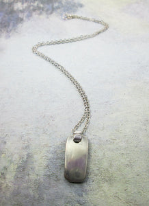 back view of metal chain necklace, showing mirror finish of pendant