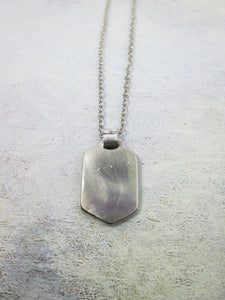 back view of sports pendant on metal chain, pendant polished to mirror finish.