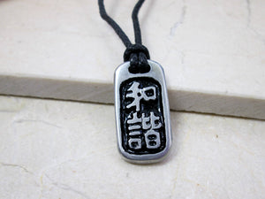 Kanji symbol for harmony and balance pendant with black background, black cord necklace style.