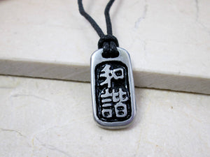 Kanji symbol for harmony and balance pendant with black background, black cord necklace style.