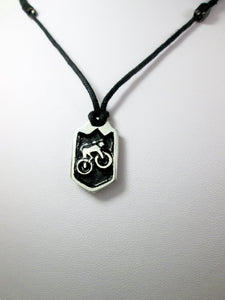 cycling pendant necklace, biker pendant necklace, pendant with black background, on black cord, for unisex teen or adult. (photo taken on a white background)