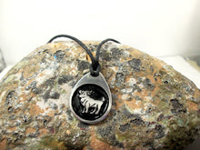 Load image into Gallery viewer, Aries horoscope necklace pendant with black background, teardrop shape, on black cord. For man or woman. (photo taken on a rock background)