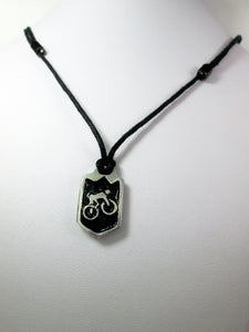 cycling pendant necklace, biker pendant necklace, pendant with black background, on black cord, for unisex teen or adult. (photo taken on a white background)