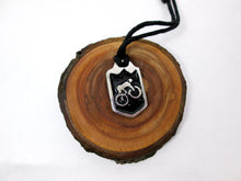 Load image into Gallery viewer, cycling pendant necklace, biker pendant necklace, pendant with black background, on black cord, for unisex teen or adult. (photo taken on a background with a piece of wood)