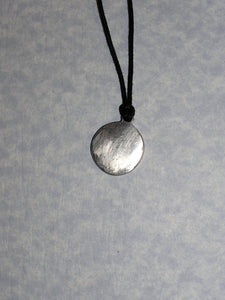back view of pendant on black cord, pendant polished to mirror finish.