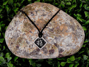 Kanji symbol for Good Luck pendant with black background, black cord necklace style.