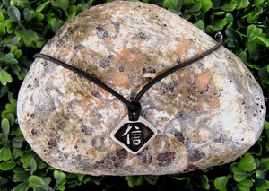 Kanji symbol for Faith and Belief pendant with black background, black cord necklace style.