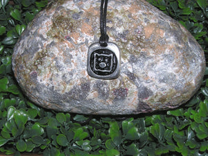 Year of the pig Chinese zodiac pendant necklace for unisex, squarish pendant with black background, cotton cord style. (picture taken on a background with a rock)