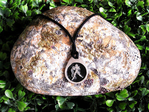Aquarius horoscope pendant necklace on black cord with black background, teardrop shaped, for man or woman. (photo taken on a rock background.)