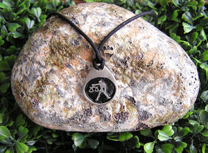 Libra horoscope pendant necklace on black cord, teardrop pendant with black background, for man or woman. (photo taken on background with a rock)