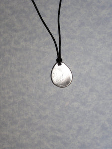 showing back of pendant, polished with mirror finish, pendant on black cord.