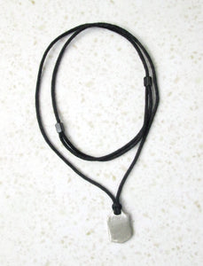 sample backview of handmade sports pendant necklace on black cord, pendant polished to mirror finish.