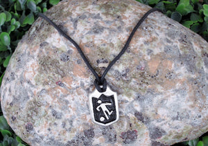 handmade soccer player pendant necklace, pendant with black background, on black cord, for men or women. (picture of necklace taken on a background with a piece of rock)
